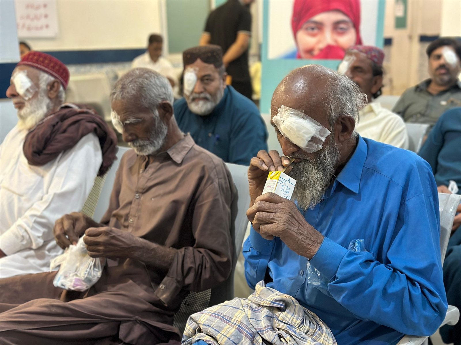 Patients with post-operative eye dressings in the PEBS Hospital Eye Unit waiting area