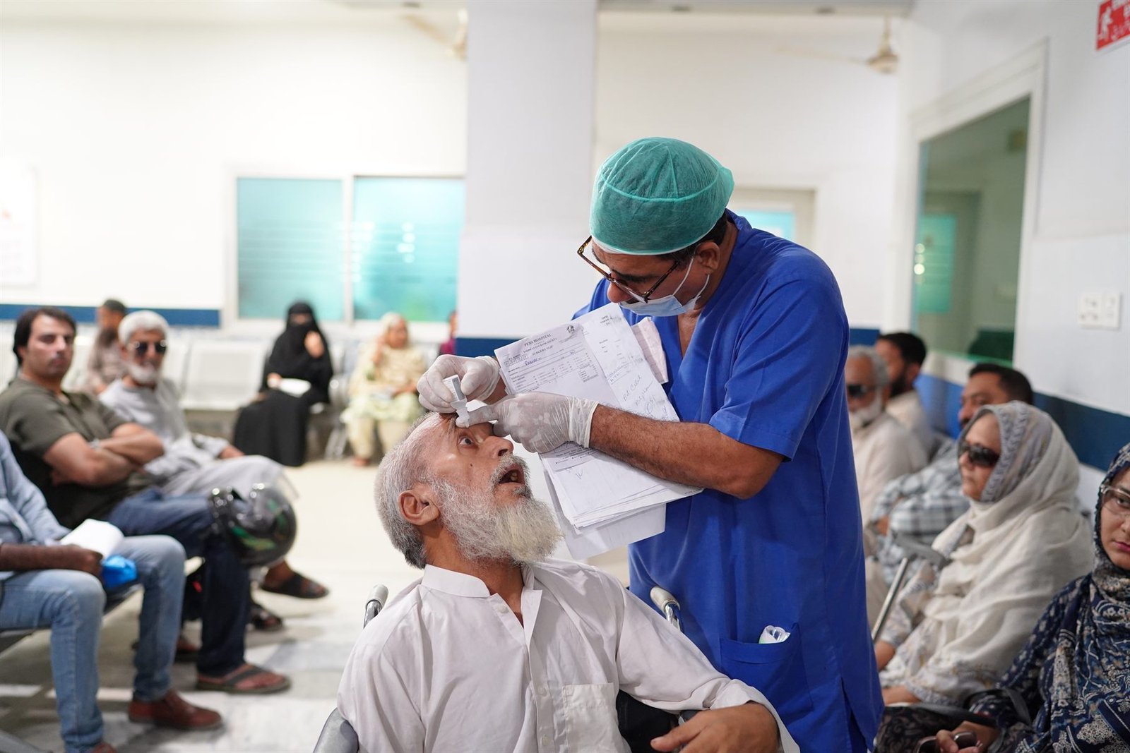 Clinician administering eye medication to an elderly patient in the Eye Unit