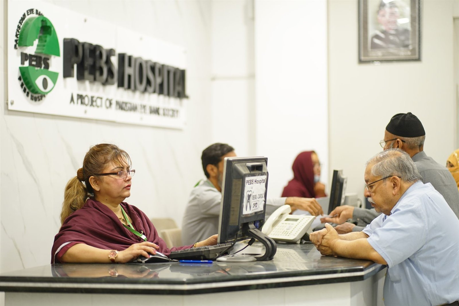Patients at the PEBS Hospital reception desk