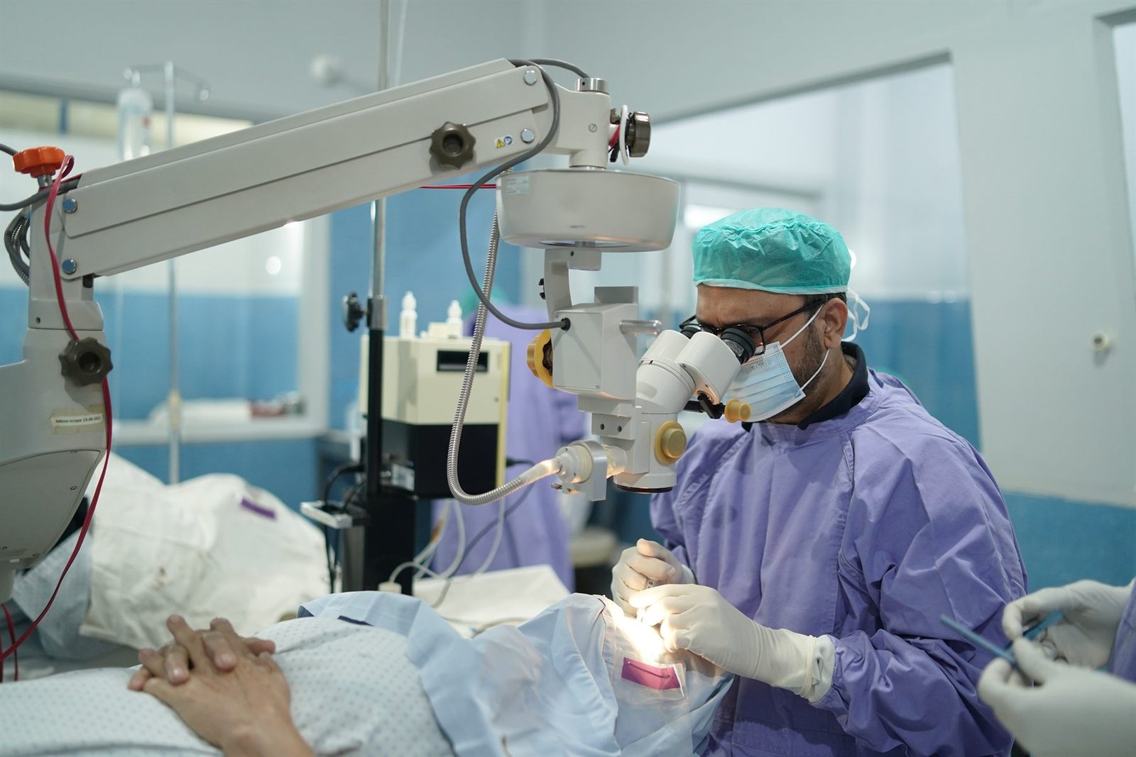 Eye surgeon operating under a surgical microscope in the PEBS Hospital operation theatre