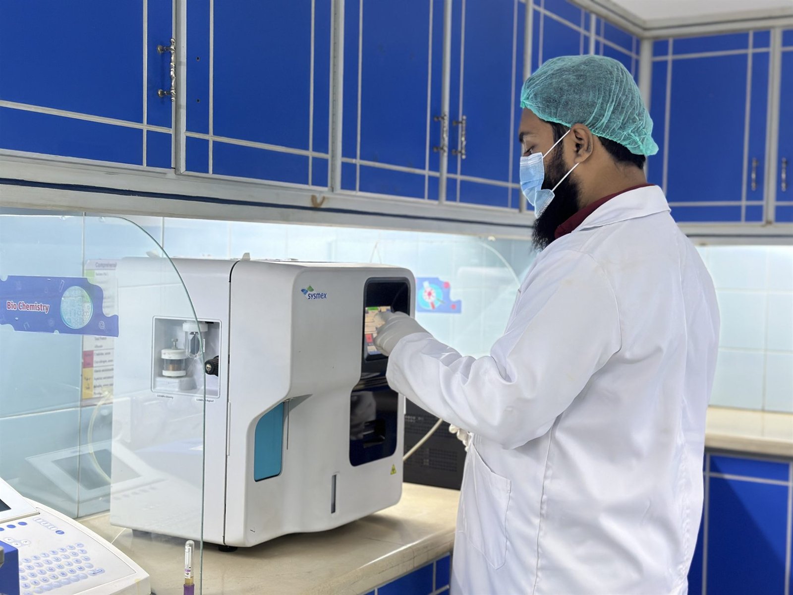 Technician operating an automated analyser in the PEBS Hospital Laboratory