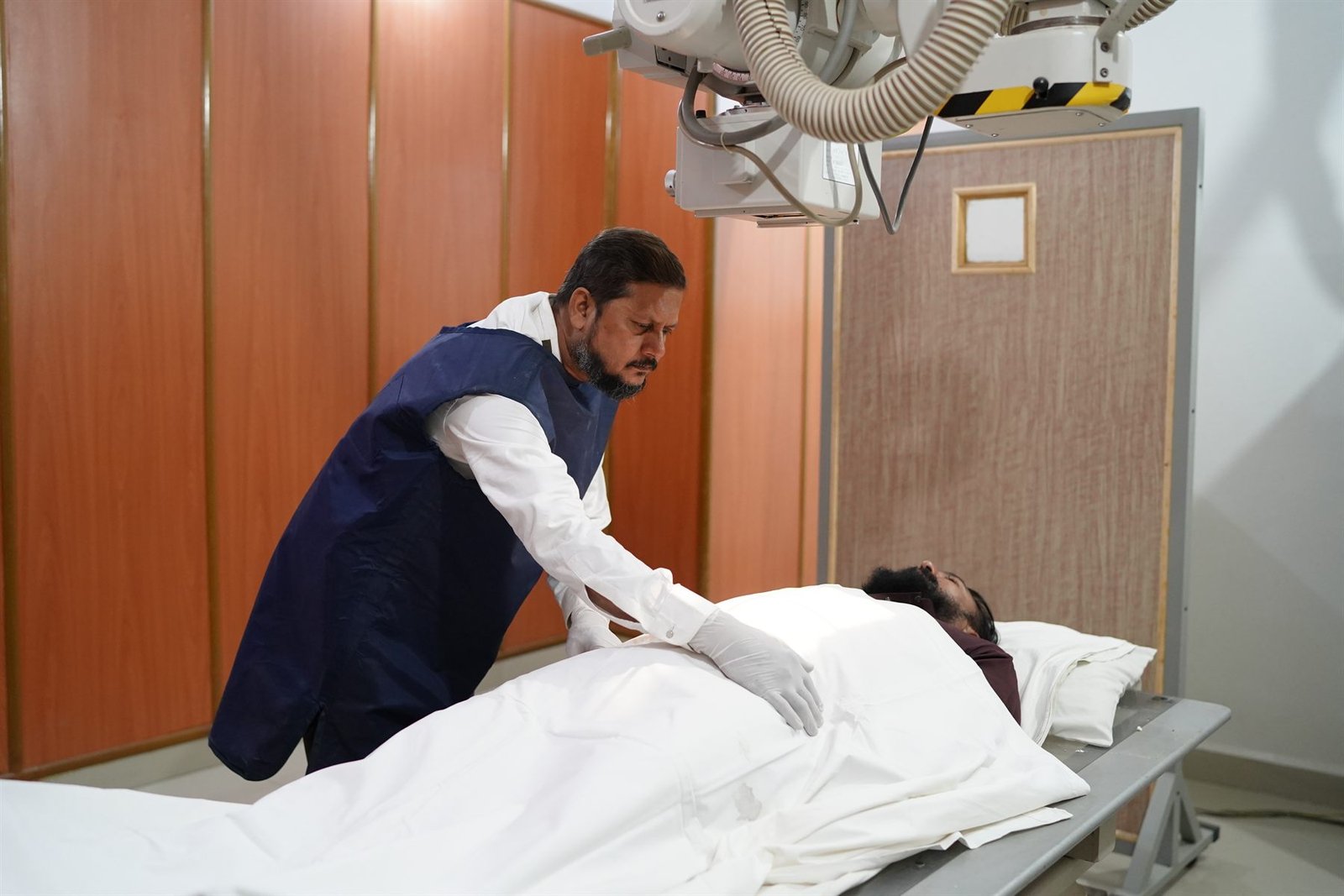 Radiographer positioning a patient for a digital X-ray at PEBS Hospital