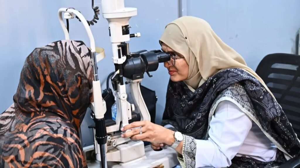 An ophthalmologist examining a patient at the slit lamp, PEBS Hospital
